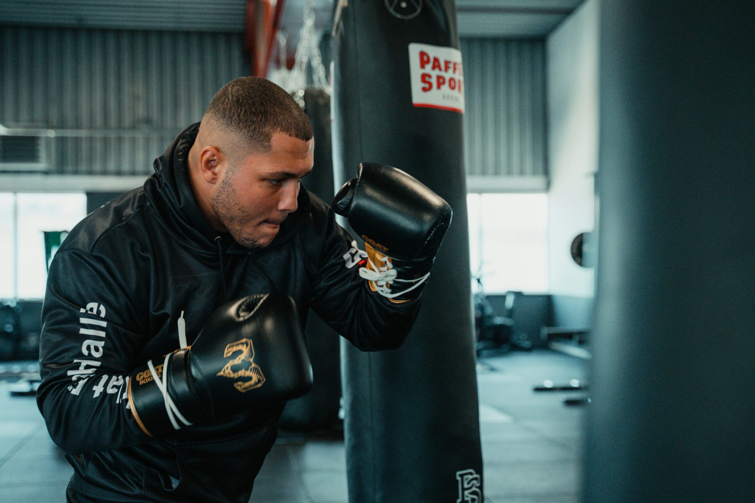 A man in a gym with a punching bag